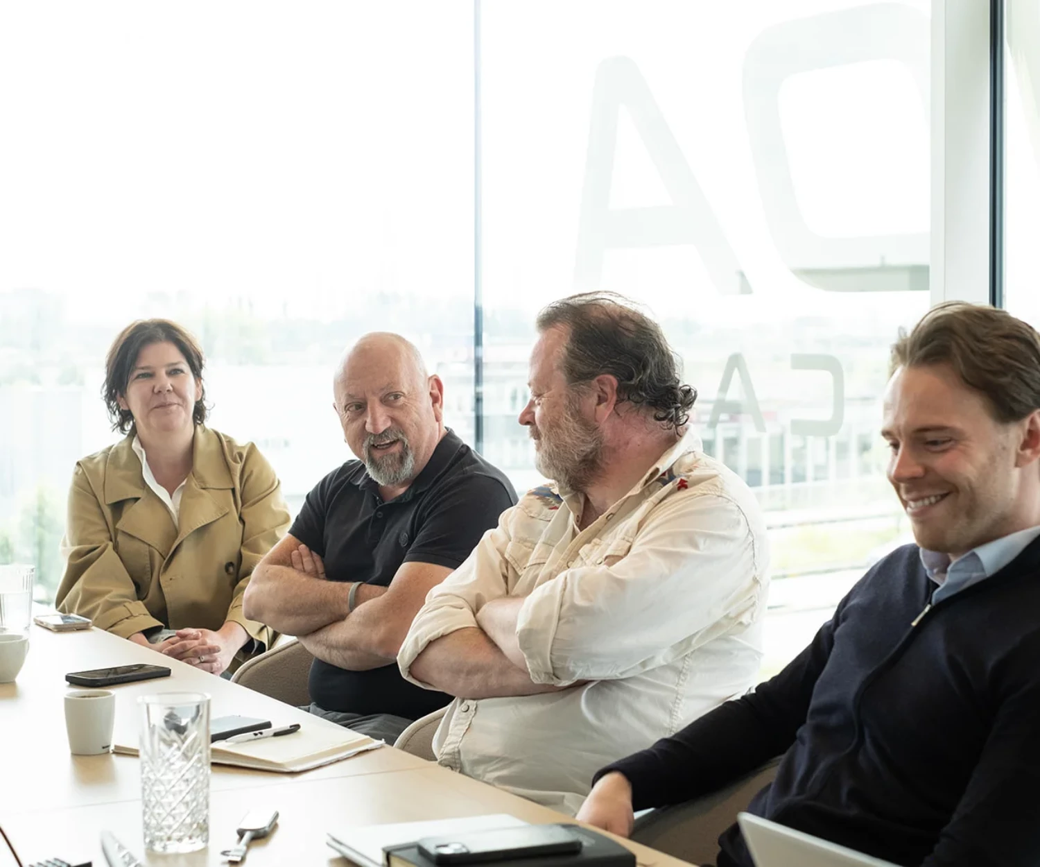 Picture of people in a meeting smiling.
